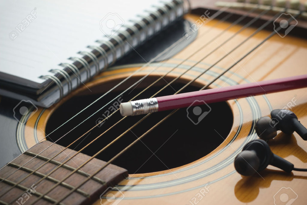 31035991-notebook-and-pencil-on-guitar-writing-music-stock-photo