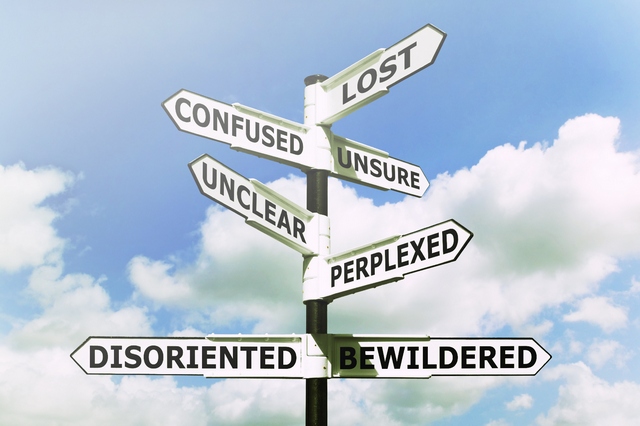 Concept image of a lost and confused signpost against a blue cloudy sky.